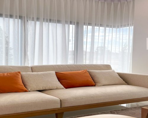 Living room interior with soft sunlight filtering through sheer curtains